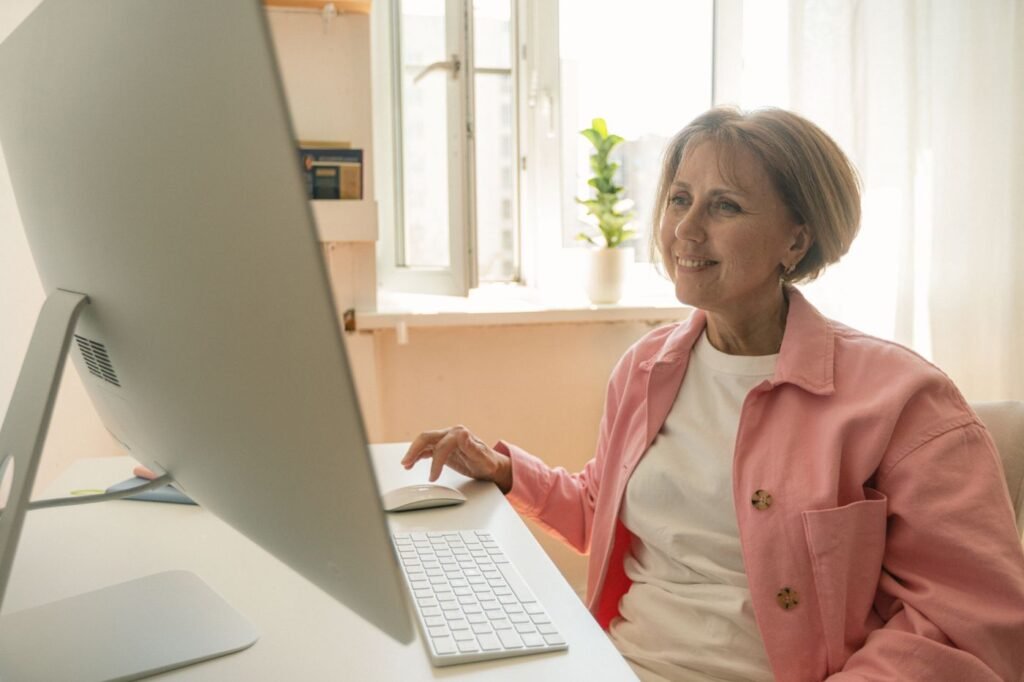 Mulher idosa usando um computador de mesa