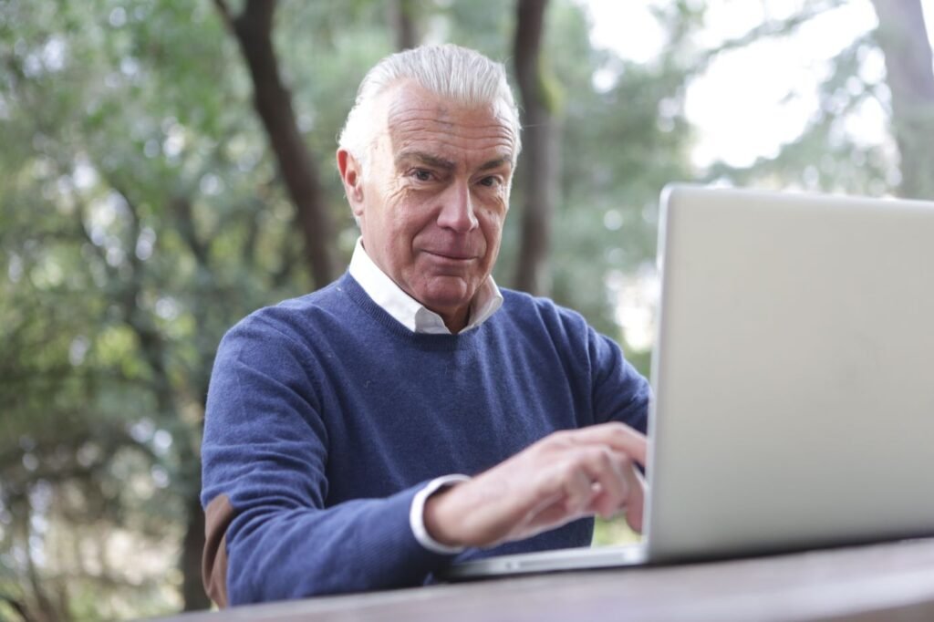 Homem de cabelos grisalhos digitando no computador