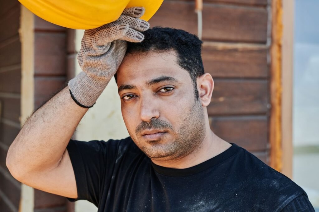 Trabalhador da construção descansando com o capacete na mão