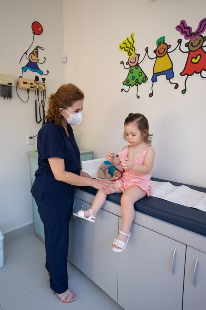 Médico com menina em consulta pediátrica
