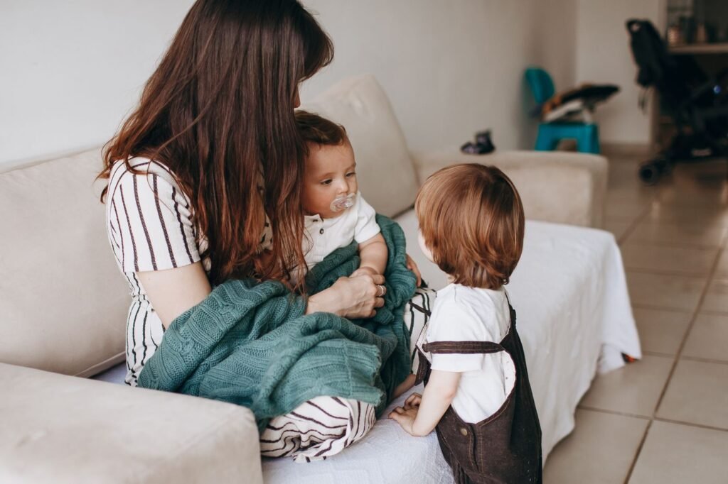 Mãe abraçada com os filhos no sofá