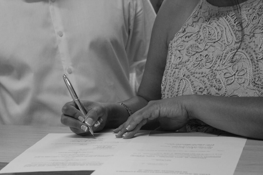 Casal assinando documento de casamento