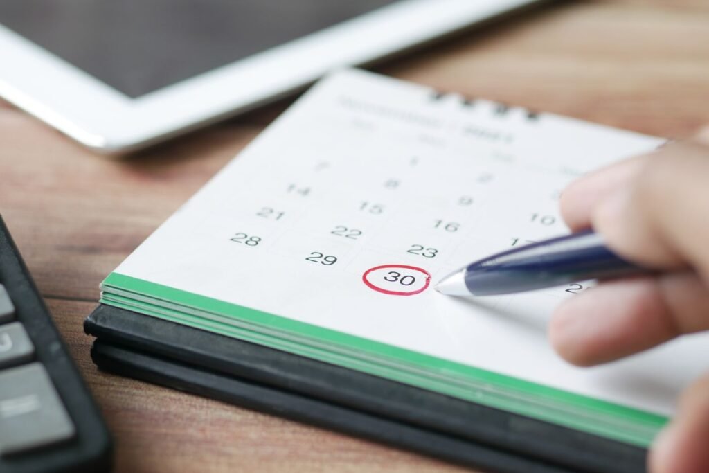 Mão marcando uma data no calendário