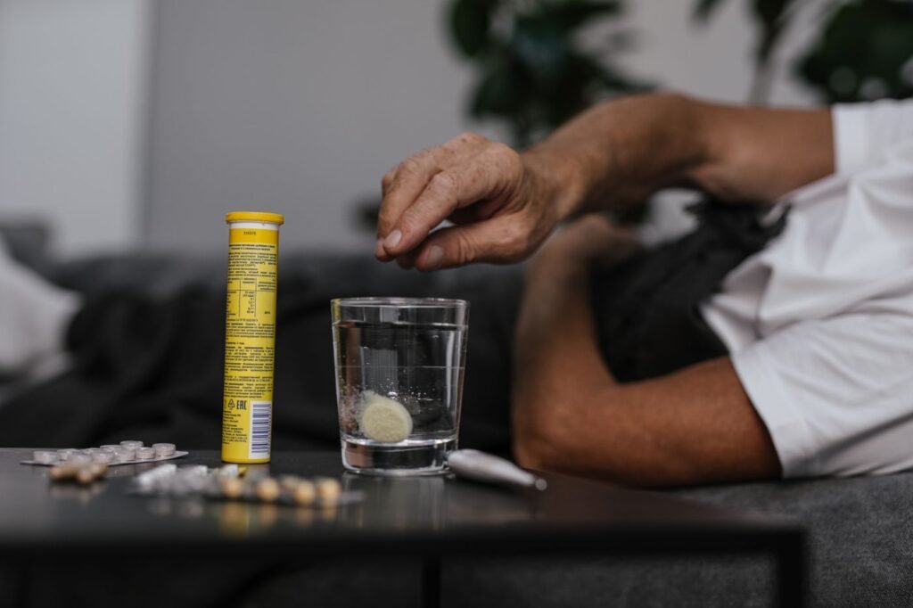 Pessoa colocando remédio em um copo de água