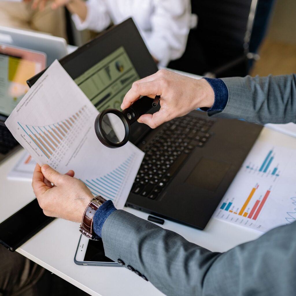 Pessoa analisando um documento com uma lupa