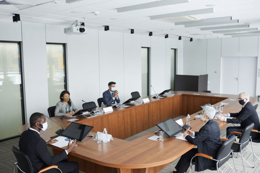 Profissionais sentados à mesa em reunião